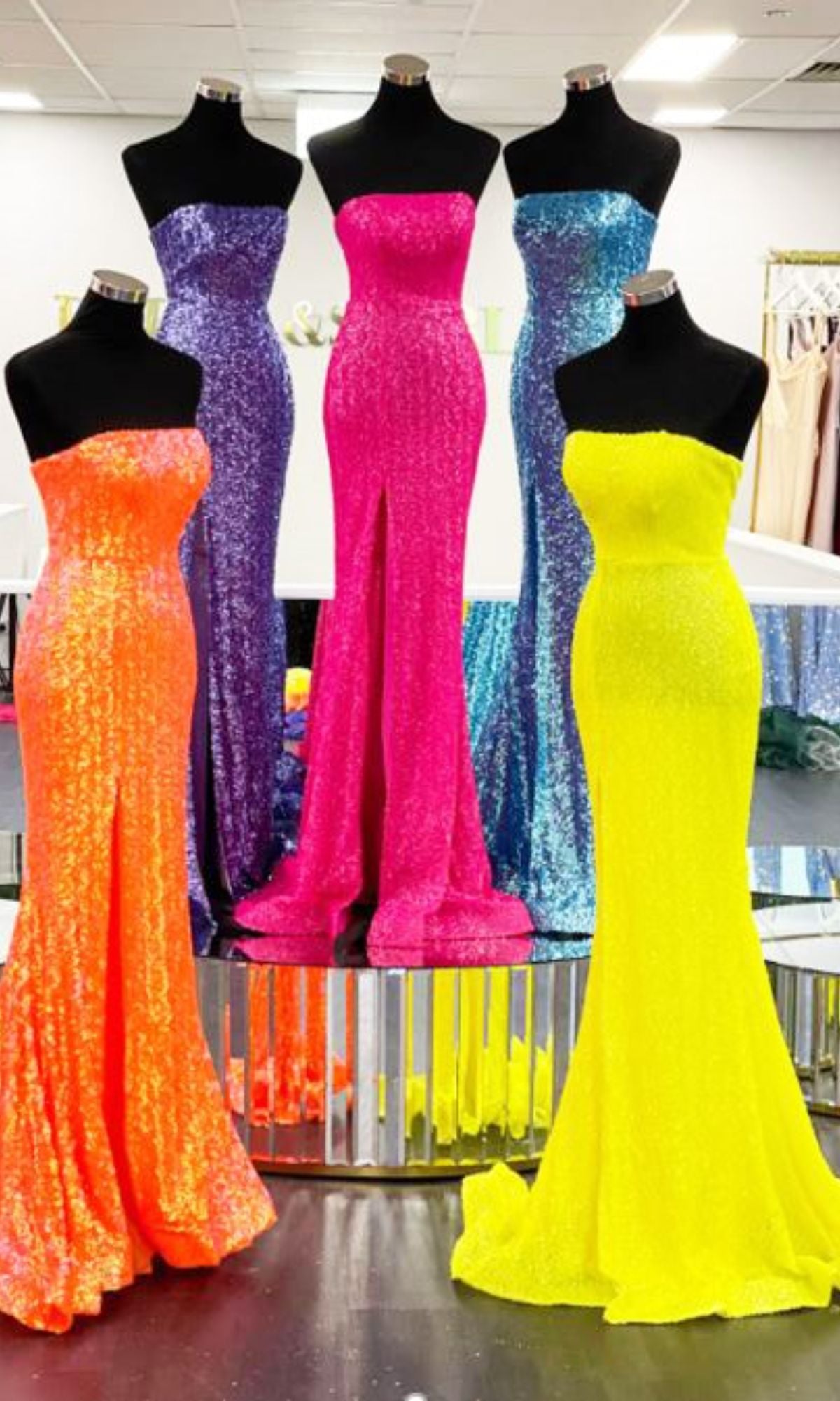 A Portia & Scarlett PS22378 long sequin prom dress in blue is displayed on a mannequin in a well-lit showroom.